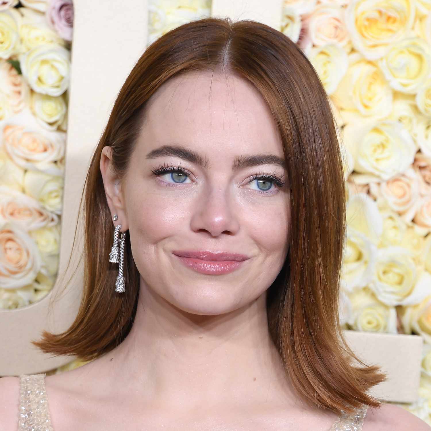 Emma Stone attends the Golden Globes with a flipped out, long bob and center part tucked behind one ear