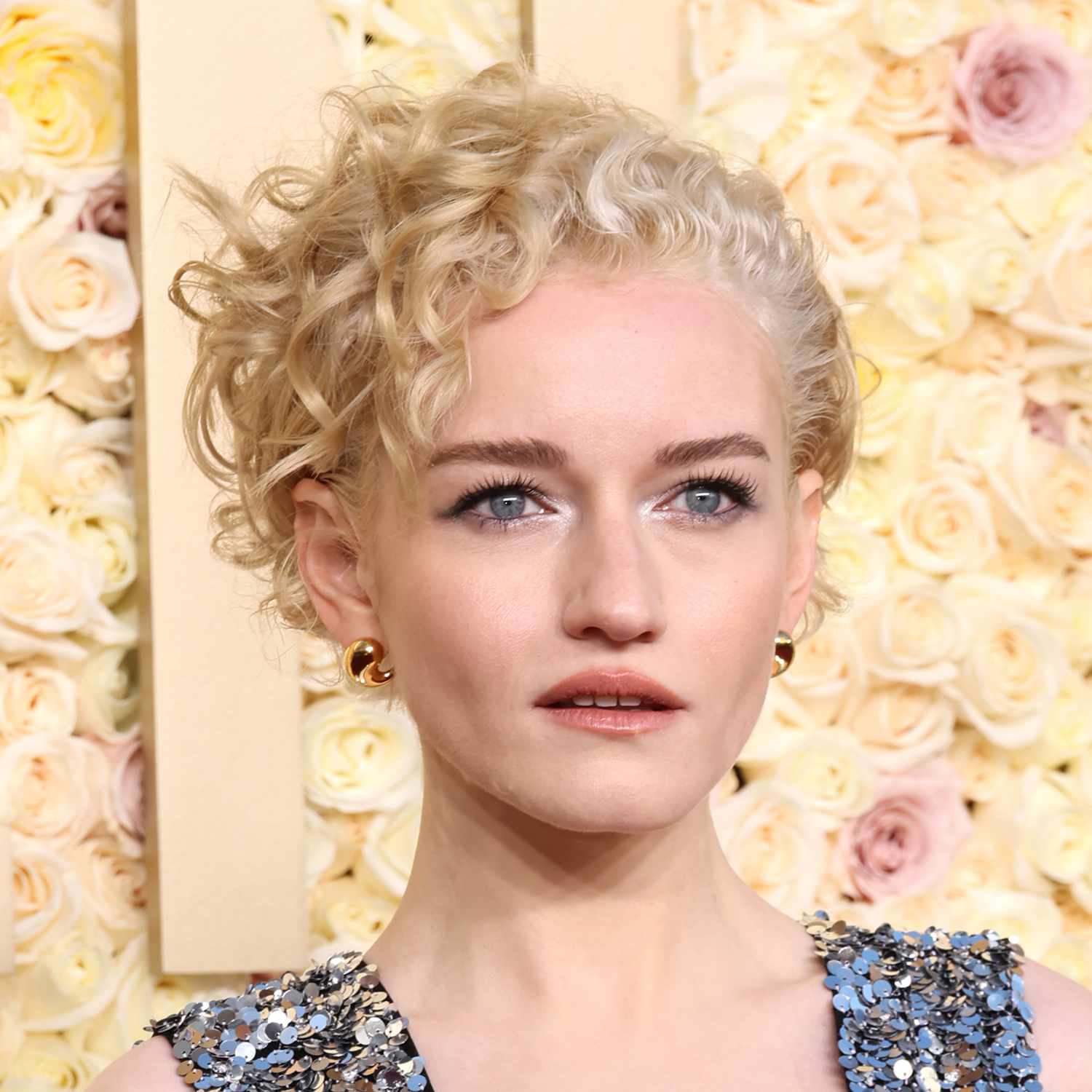 Julia Garner attends the Golden Globes with a curly pixie in an over directed style