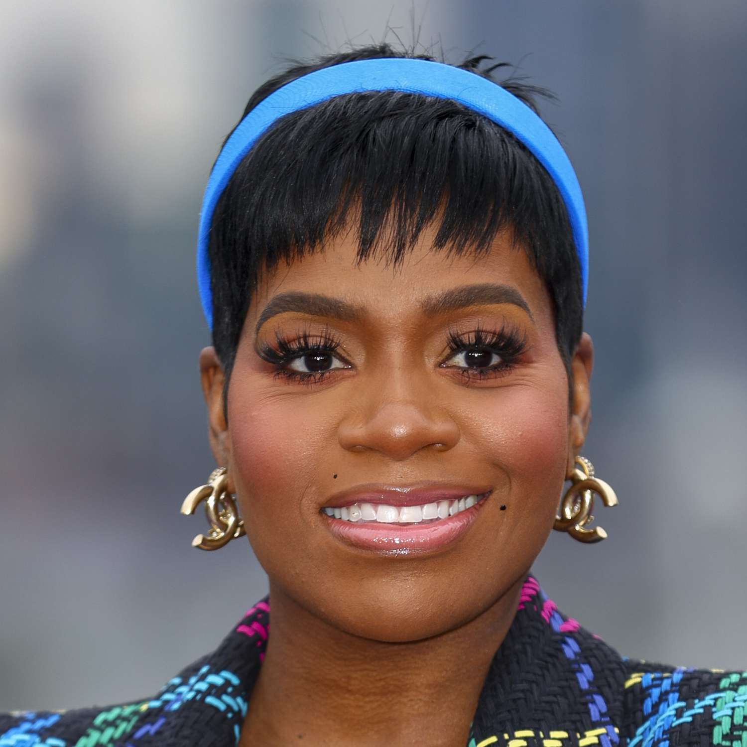 Fantasia attends a film premiere in London wearing a choppy fringed pixie adorned with a bright blue headband