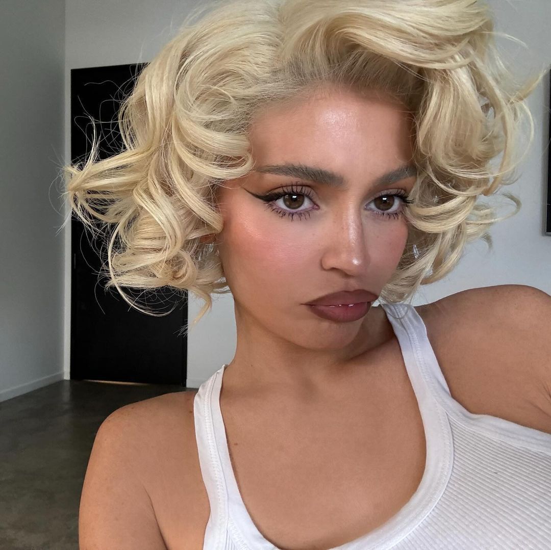 Kylie Jenner wearing a curly blonde bob hairstyle.