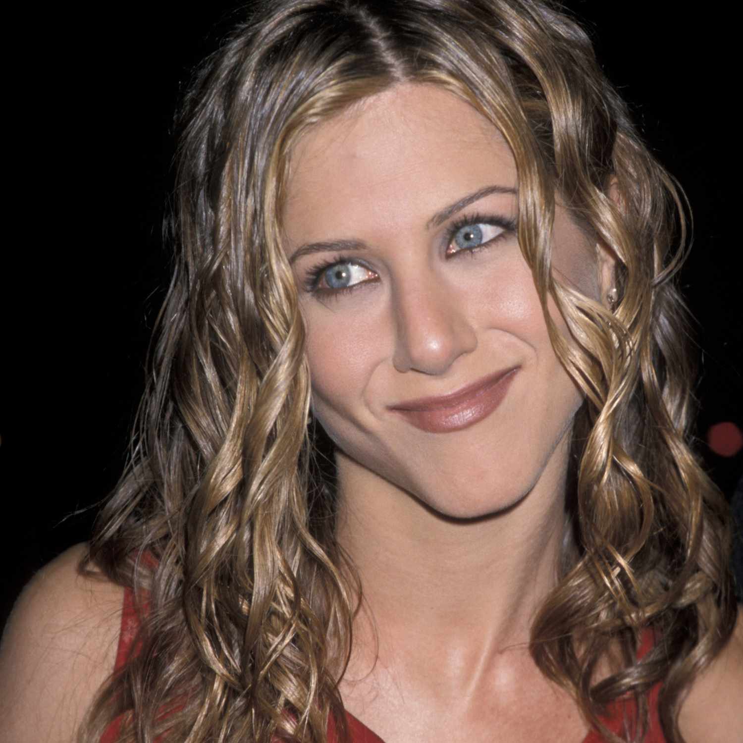 close up of jennifer aniston's hair, middle part, wet looking spiral curls